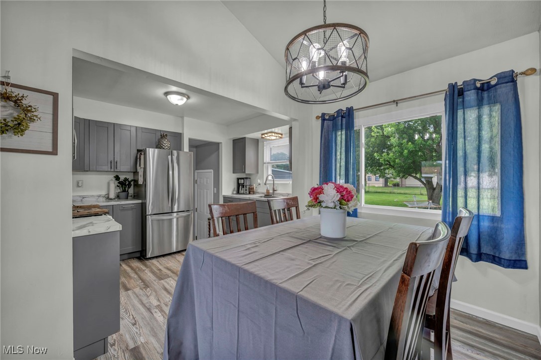15025 Holland Road Brook Park, OH 44142 - Photo 5 of 12 Dining area with light wood-type flooring, a chandelier, and vaulted ceiling