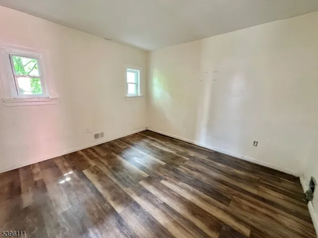 a view of a room that has wooden floor and window