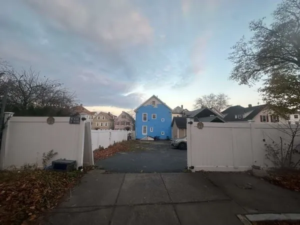 a view of a house with a yard and large tree