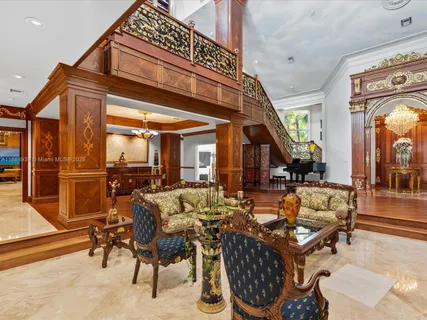 a living room with furniture a piano and a large window