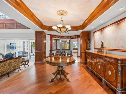 a dining room with furniture large windows and a chandelier