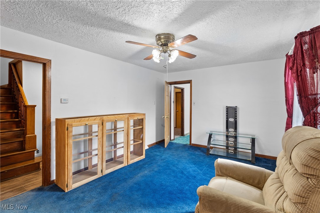 102 Potrock Road Wellsburg, WV 26070 - Photo 6 of 42 Living area with stairway, carpet floors, a textured ceiling, and ceiling fan