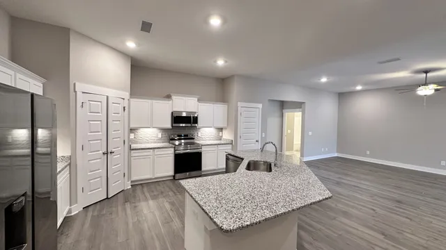 a kitchen with stainless steel appliances a refrigerator sink and stove