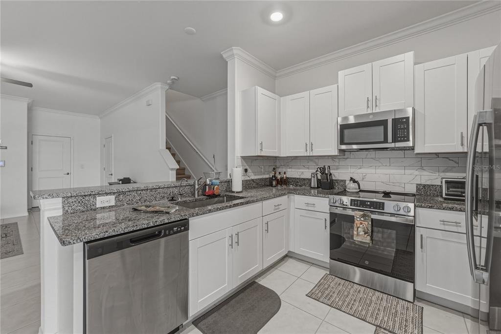 30688 Veridian Way Wesley Chapel, FL 33543 - Photo 11 of 55 a kitchen with stainless steel appliances granite countertop a stove sink and cabinets