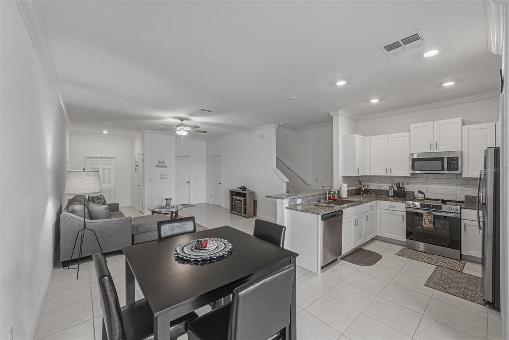 30688 Veridian Way Wesley Chapel, FL 33543 - Photo 14 of 55 a kitchen with stainless steel appliances granite countertop a stove top oven a sink dishwasher and a refrigerator with wooden floor