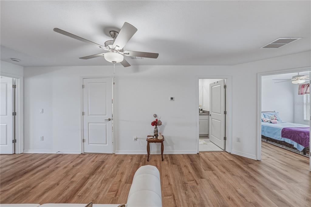 30688 Veridian Way Wesley Chapel, FL 33543 - Photo 22 of 55 a view of a room with wooden floor and ceiling fan