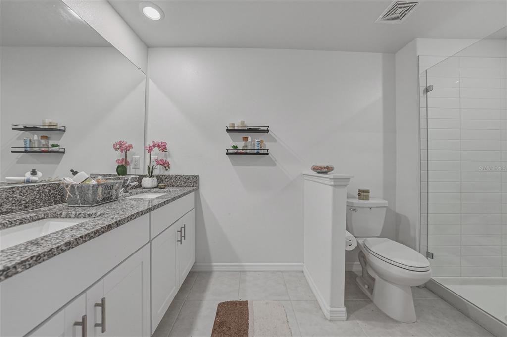 30688 Veridian Way Wesley Chapel, FL 33543 - Photo 29 of 55 a bathroom with a granite countertop sink a toilet and a mirror