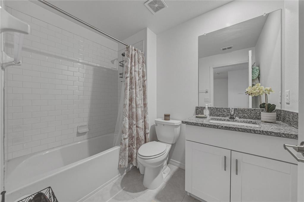 30688 Veridian Way Wesley Chapel, FL 33543 - Photo 37 of 55 a bathroom with a granite countertop sink a toilet and a bathtub