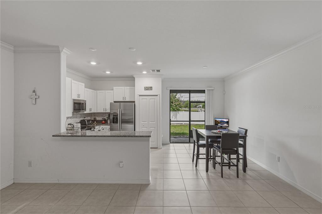 30688 Veridian Way Wesley Chapel, FL 33543 - Photo 10 of 55 a kitchen with kitchen island a stove a table and chairs in it