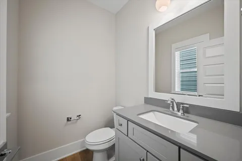 a bathroom with a granite countertop sink toilet and a mirror