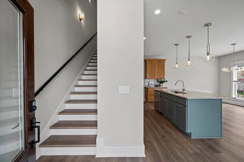 a kitchen with stainless steel appliances granite countertop a sink a stove and a wooden floors