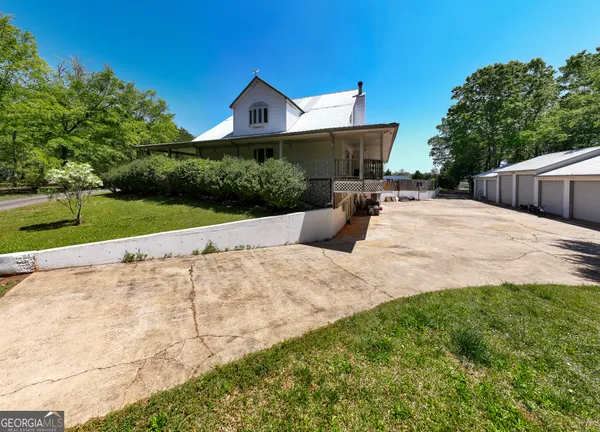 a view of a house with a yard and potted plants