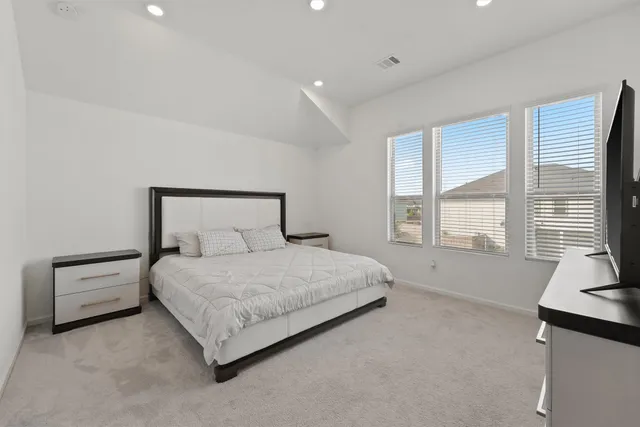 a spacious bedroom with a bed and a couch