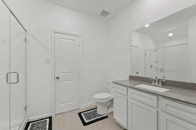 a bathroom with a granite countertop sink a toilet and a shower