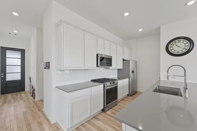 a kitchen with stainless steel appliances granite countertop a white stove top oven and sink