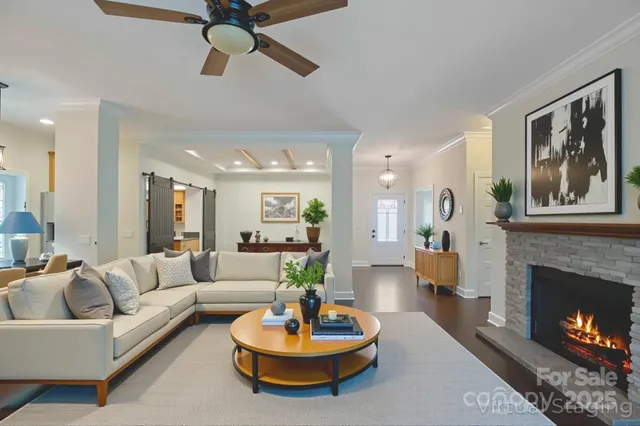 a living room with furniture a fireplace and a chandelier