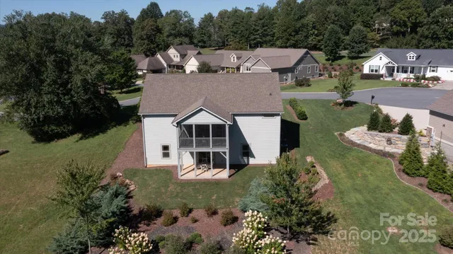 an aerial view of a house with garden space and trees all around