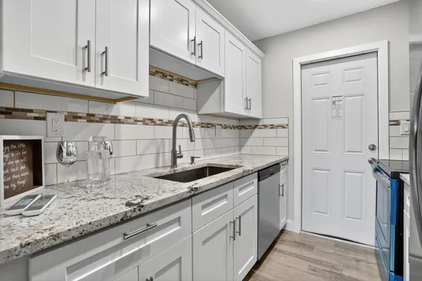 a kitchen with granite countertop a sink and cabinets