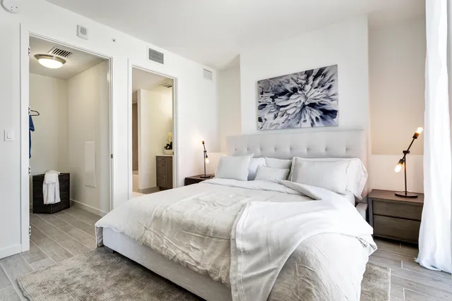 a bedroom with a bed and a painting on the wall