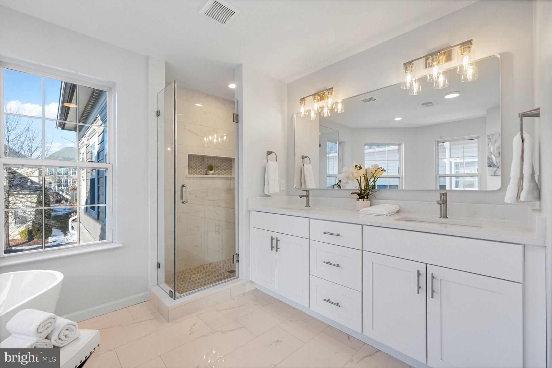 8329 Tillett Loop Manassas, VA 20110 - Photo 16 of 27 a spacious bathroom with a double vanity sink a mirror and a shower