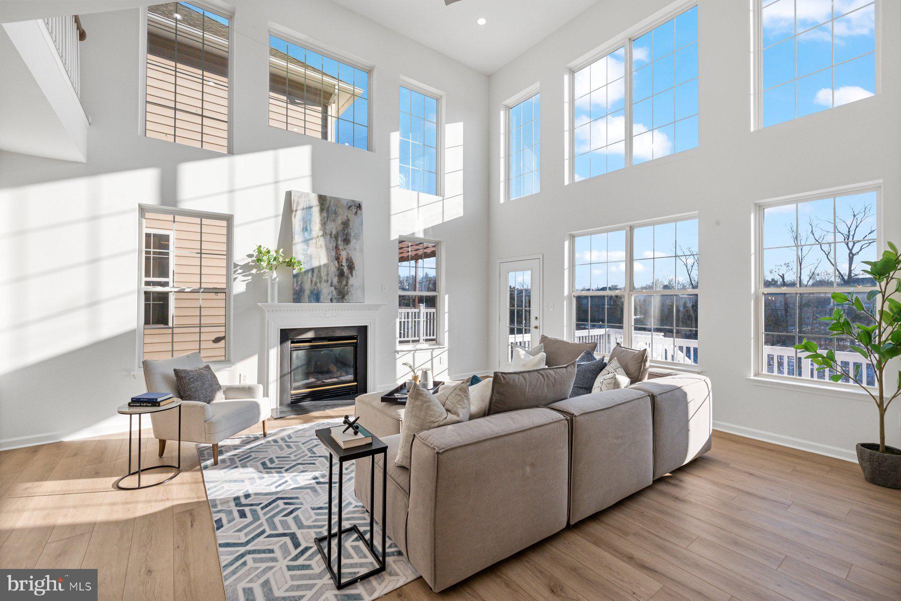 8329 Tillett Loop Manassas, VA 20110 - Photo 4 of 27 a living room with furniture a fireplace and a large window
