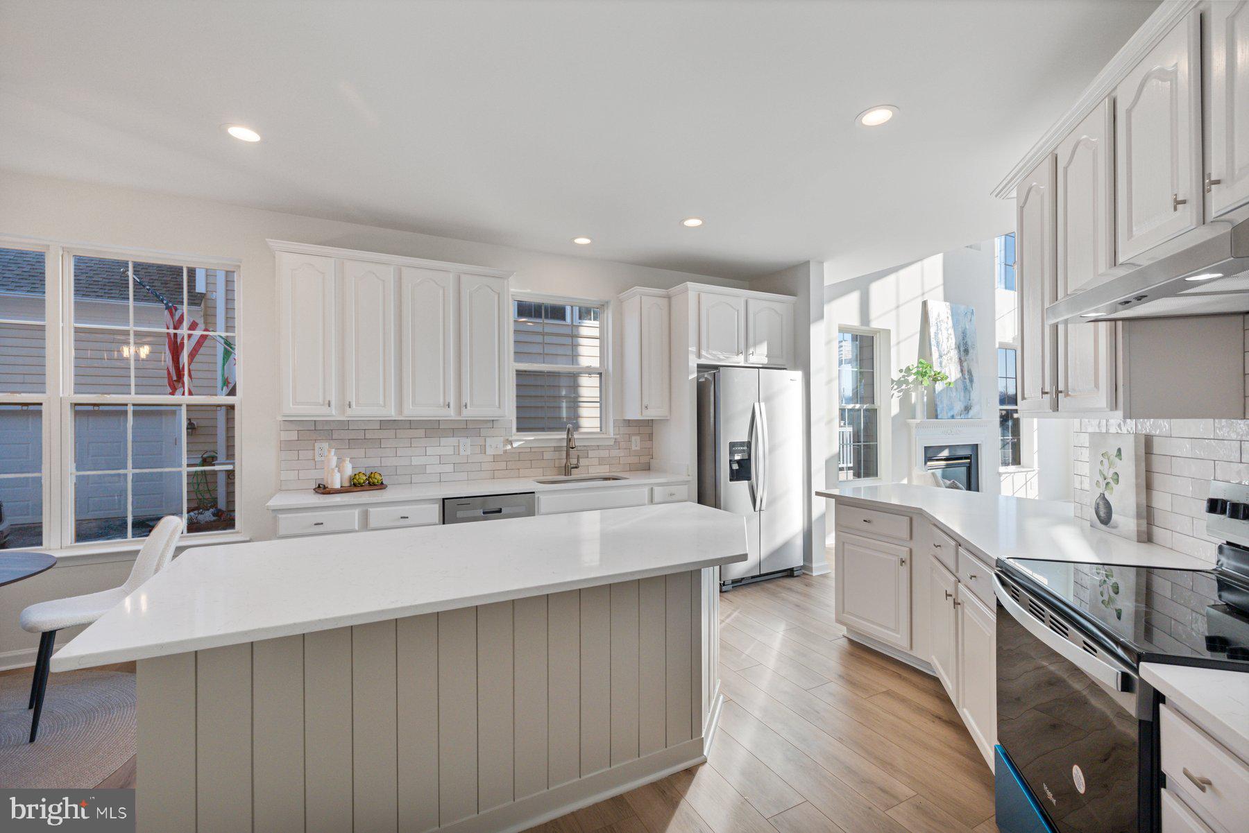 8329 Tillett Loop Manassas, VA 20110 - Photo 5 of 27 a large kitchen with stainless steel appliances a sink a stove a refrigerator and cabinets