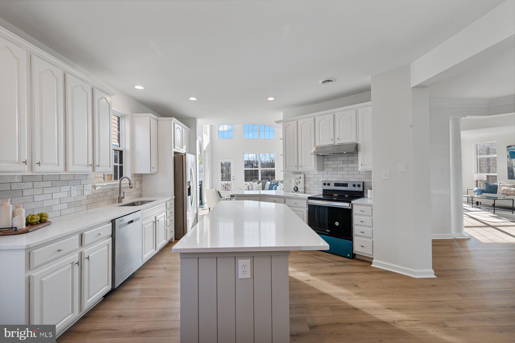 8329 Tillett Loop Manassas, VA 20110 - Photo 6 of 27 a large kitchen with stainless steel appliances granite countertop a stove top oven a sink dishwasher and a refrigerator with wooden floor