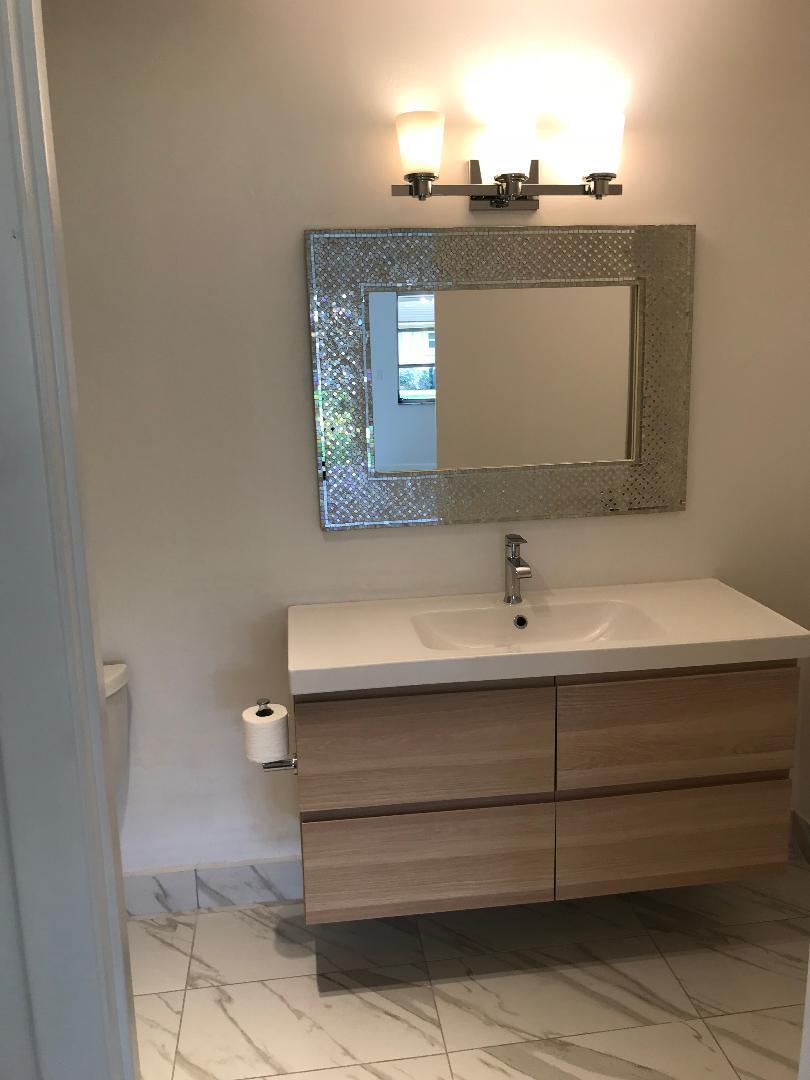 1387 High Point Way Northwest, Unit B Delray Beach, FL 33445 - Photo 11 of 16 a bathroom with a sink and a mirror