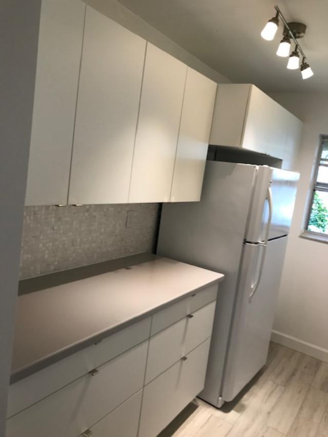 1387 High Point Way Northwest, Unit B Delray Beach, FL 33445 - Photo 7 of 16 a kitchen with cabinets and a stove