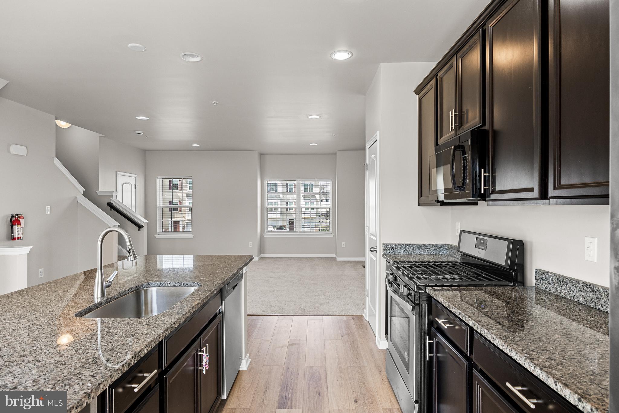 13 Iron Gate Road Sicklerville, NJ 08081 - Photo 14 of 25 a kitchen with stainless steel appliances granite countertop a sink a stove top oven and cabinetry