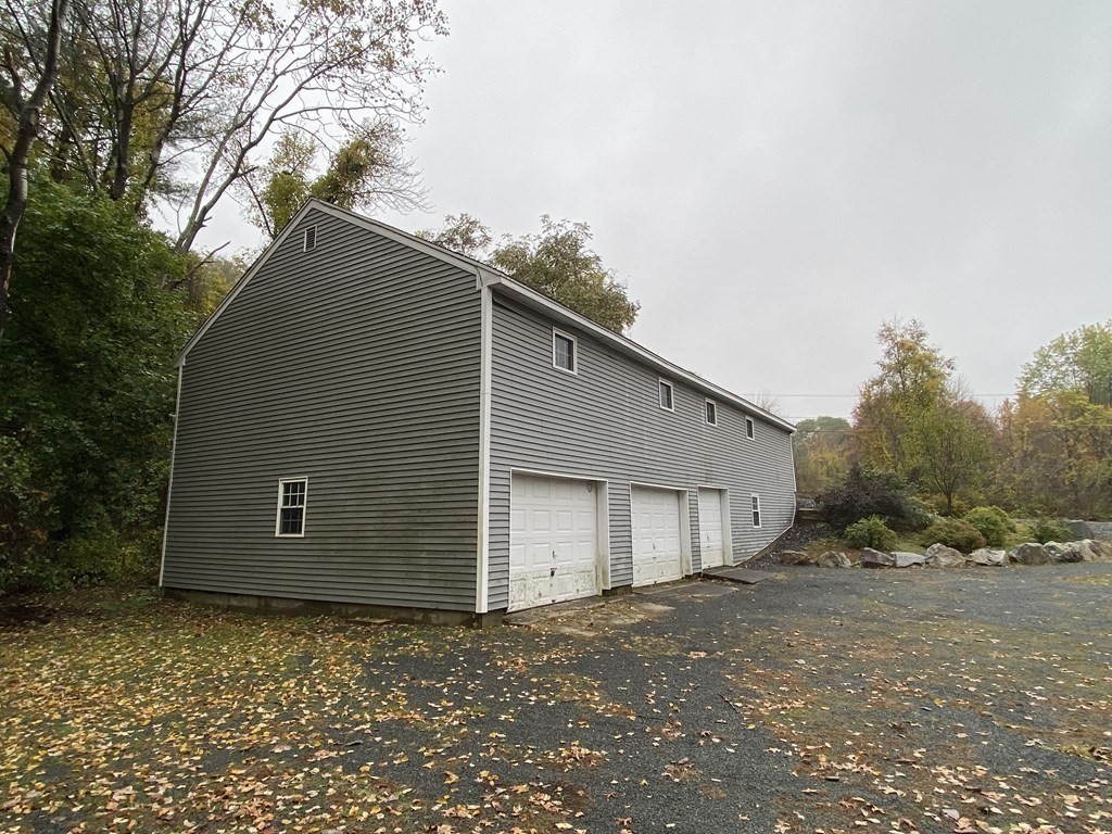 26 Hillside Road Montague, MA 01351 - Photo 12 of 12 a backyard of a house with a yard and garage