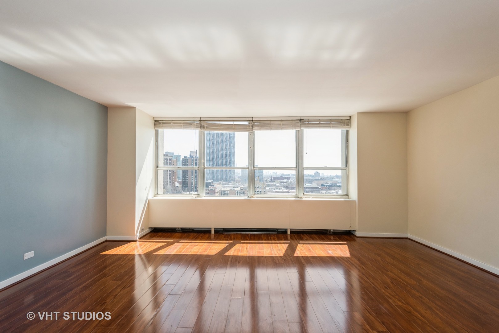 655 West Irving Park Road, Unit 1109 Chicago, IL 60613 - Photo 12 of 29 an empty room with wooden floor and windows