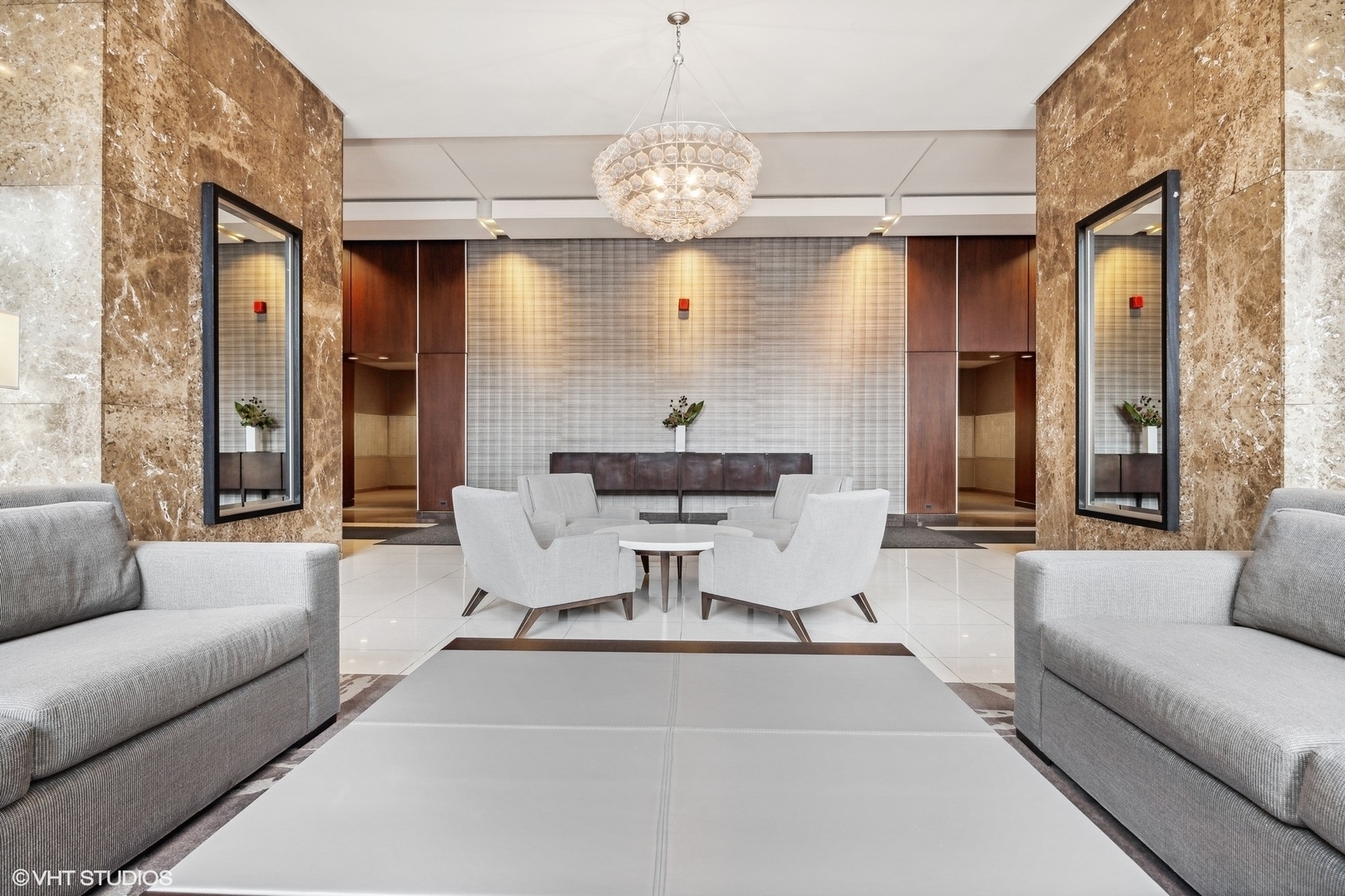 655 West Irving Park Road, Unit 1109 Chicago, IL 60613 - Photo 5 of 29 a living room with couch a dining table and a chandelier