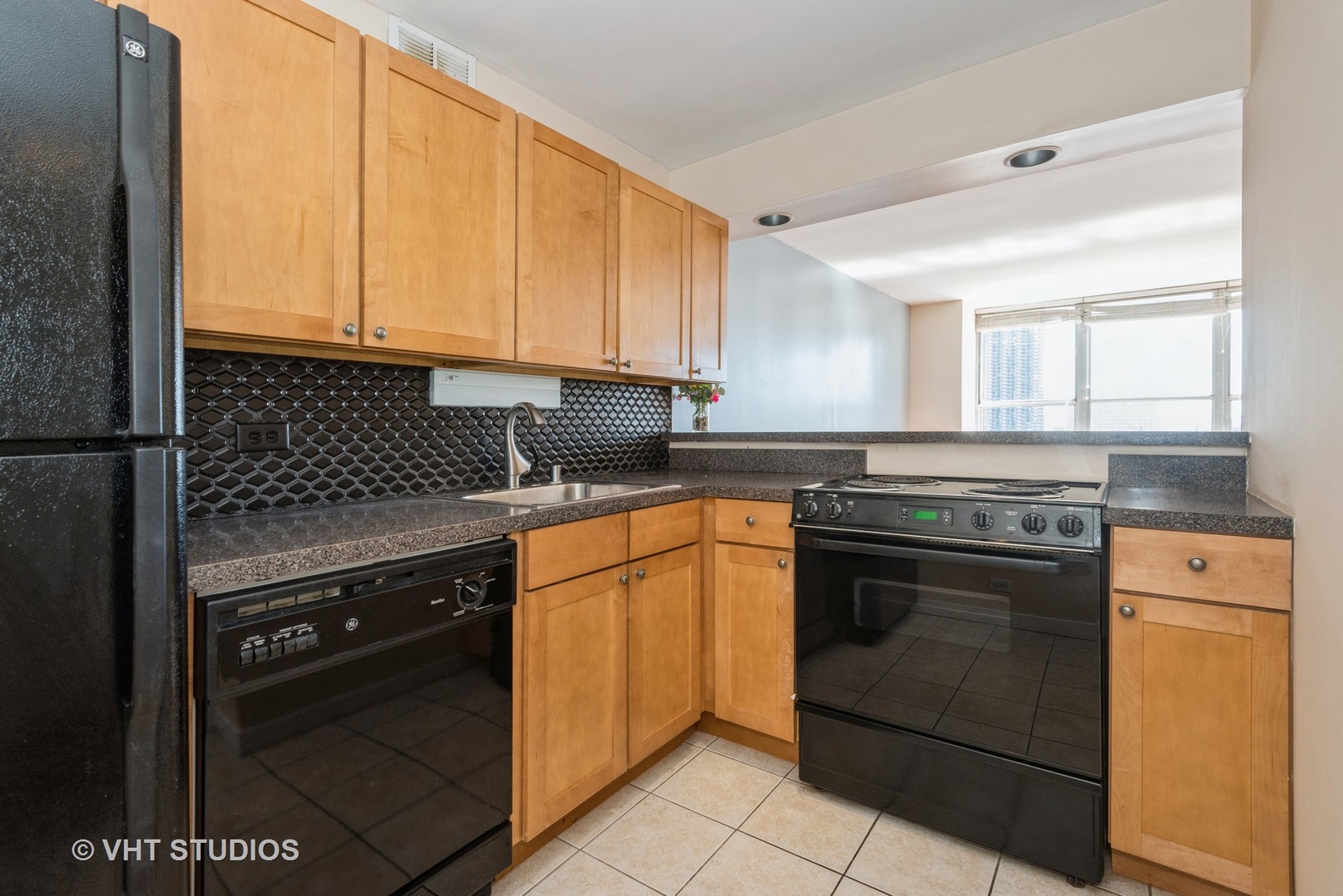 655 West Irving Park Road, Unit 1109 Chicago, IL 60613 - Photo 9 of 29 a kitchen with stainless steel appliances granite countertop a stove a sink and a microwave
