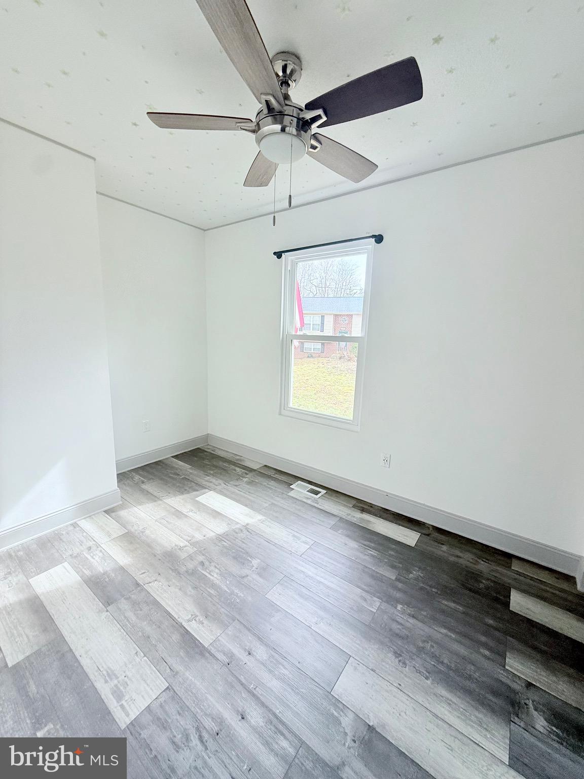 428 Buffalo Road Lusby, MD 20657 - Photo 16 of 20 an empty room with wooden floor and ceiling fan