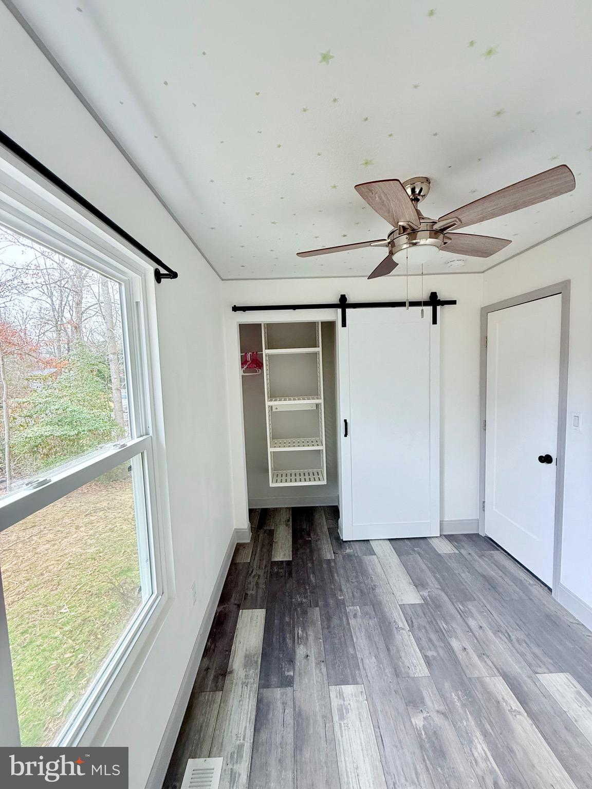 428 Buffalo Road Lusby, MD 20657 - Photo 17 of 20 a view of empty room with wooden floor and fan