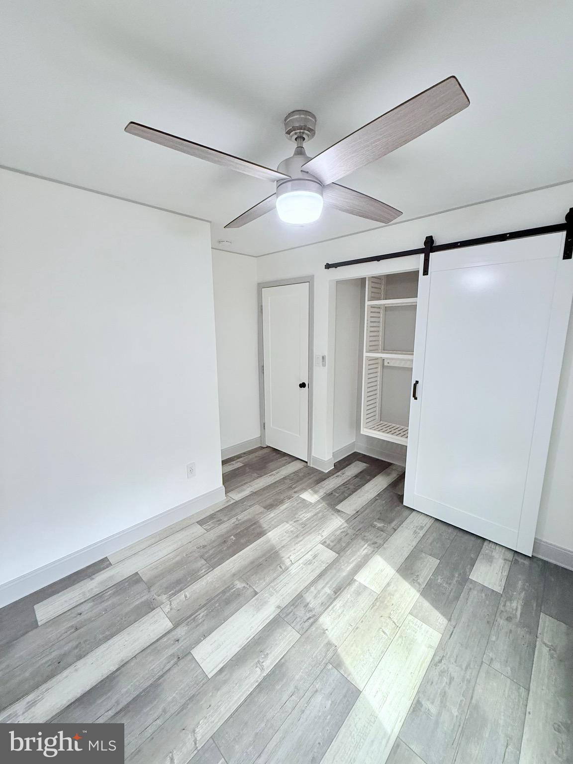 428 Buffalo Road Lusby, MD 20657 - Photo 18 of 20 a view of a room with wooden floor and a ceiling fan