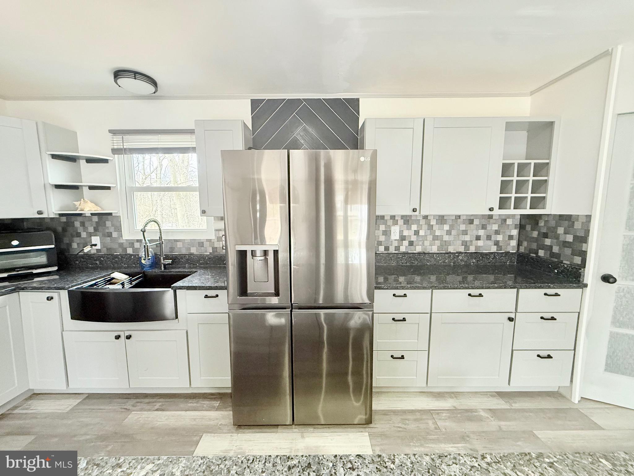 428 Buffalo Road Lusby, MD 20657 - Photo 9 of 20 a kitchen with stainless steel appliances kitchen island granite countertop a refrigerator and cabinets