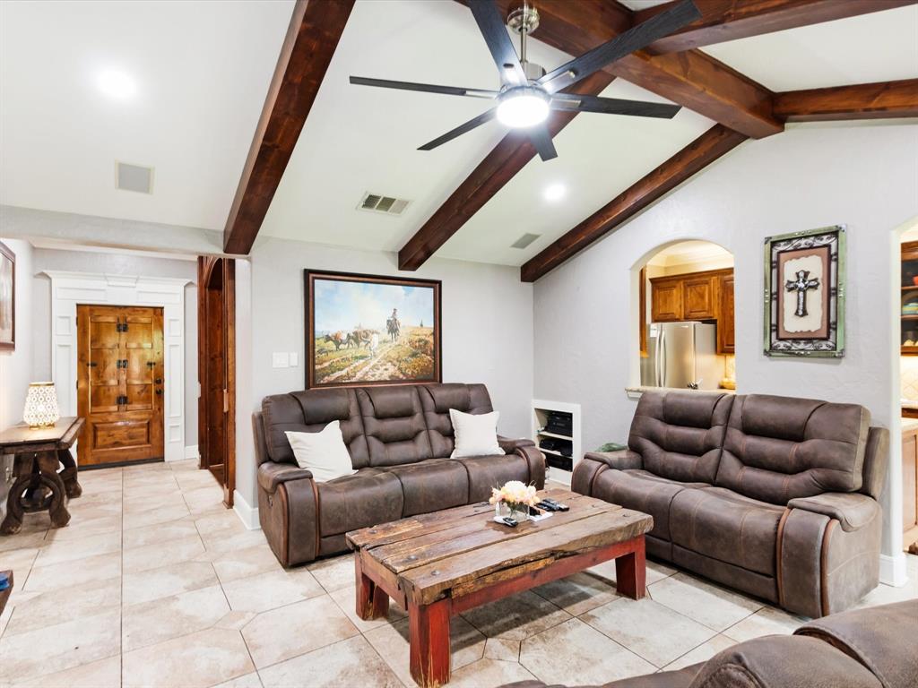 1616 Springbrook Street Mesquite, TX 75149 - Photo 16 of 24 Vaulted ceiling with exposed wood beams, tile flooring, recessed lighting, and a decorative wood-paneled door