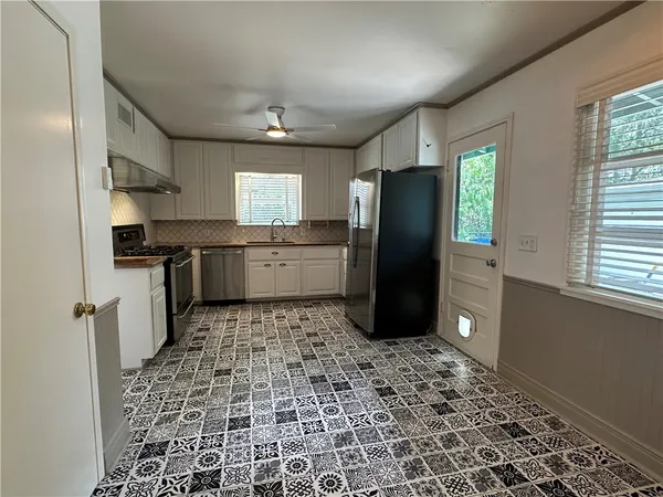 a kitchen with stainless steel appliances granite countertop a refrigerator and a sink