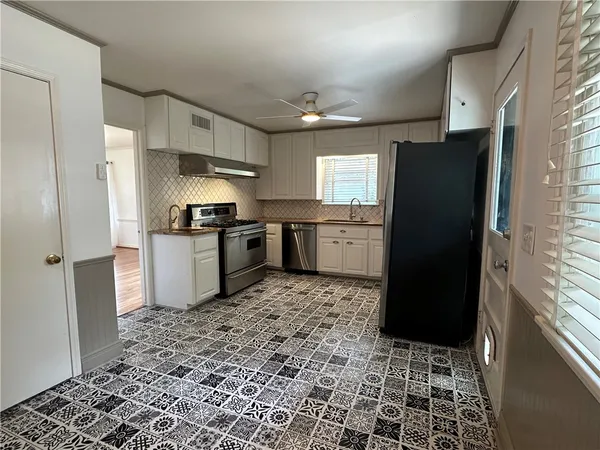 a kitchen with stainless steel appliances granite countertop a refrigerator stove and sink