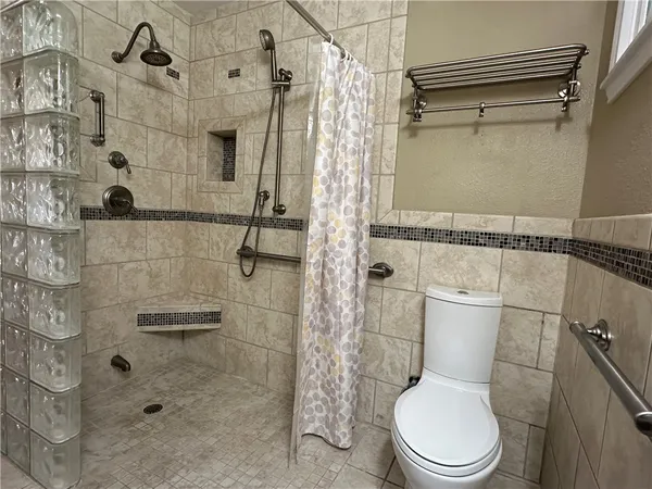 a white toilet sitting next to a bathroom shower