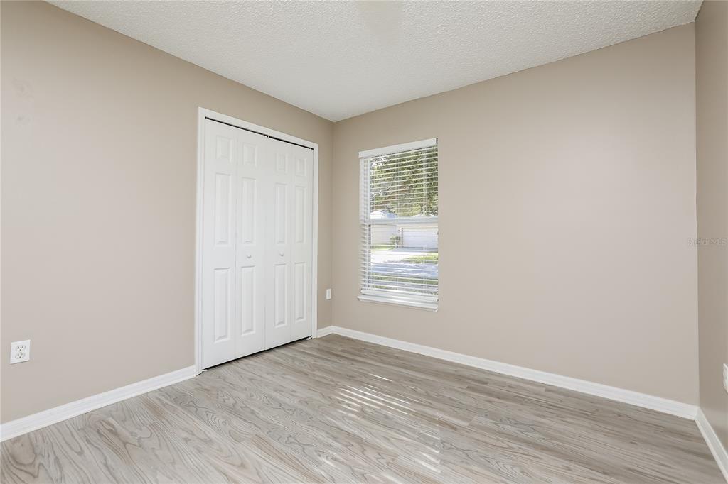 977 Vanderbilt Drive Eustis, FL 32726 - Photo 11 of 16 a view of an empty room with wooden floor and a window