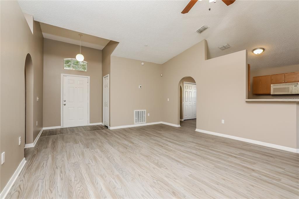 977 Vanderbilt Drive Eustis, FL 32726 - Photo 2 of 16 a view of an empty room with wooden floor and a window