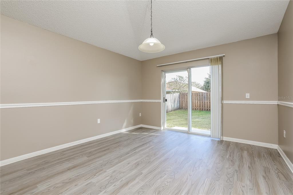 977 Vanderbilt Drive Eustis, FL 32726 - Photo 3 of 16 a view of an empty room with wooden floor and a window