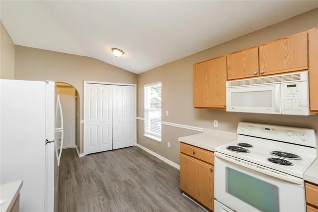 a kitchen with a stove cabinets and wooden floor