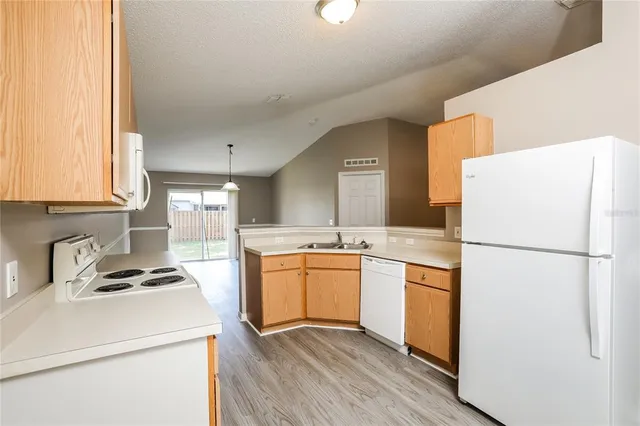 a kitchen with a refrigerator sink stove and cabinets