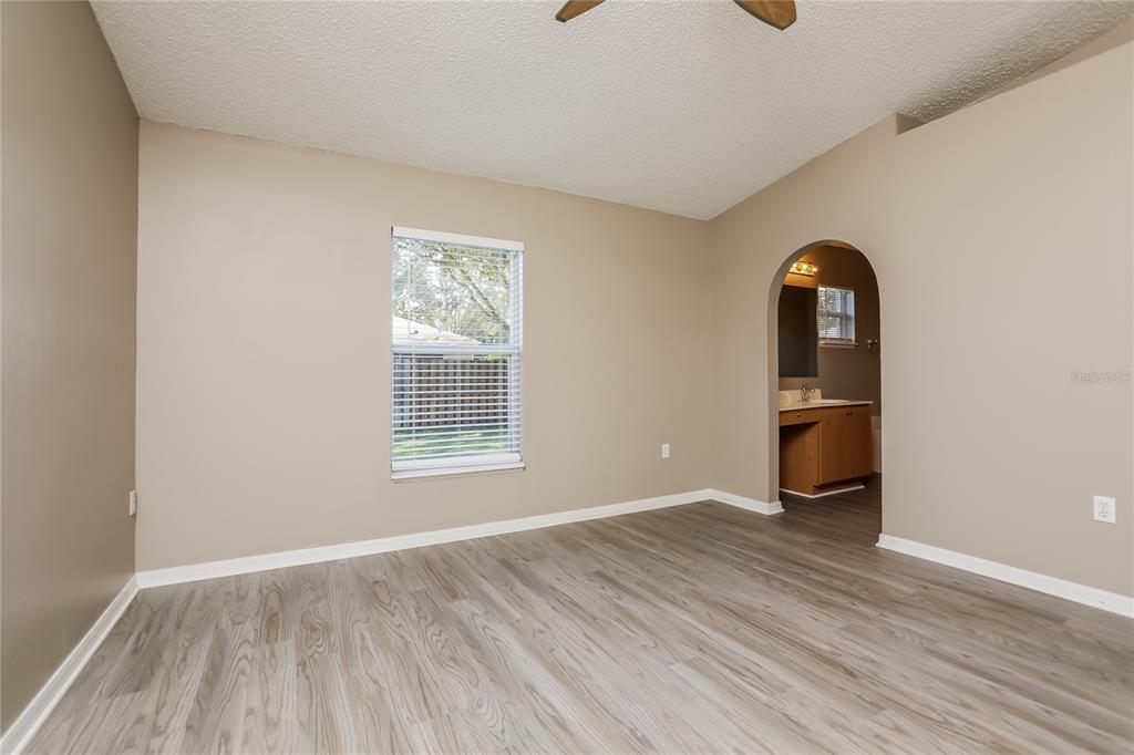977 Vanderbilt Drive Eustis, FL 32726 - Photo 7 of 16 a view of an empty room with a window and wooden floor