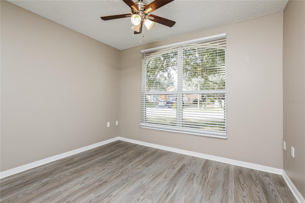 977 Vanderbilt Drive Eustis, FL 32726 - Photo 9 of 16 a view of an empty room with wooden floor and a window