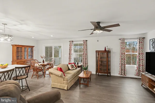 a living room with furniture floor to ceiling window and a flat screen tv